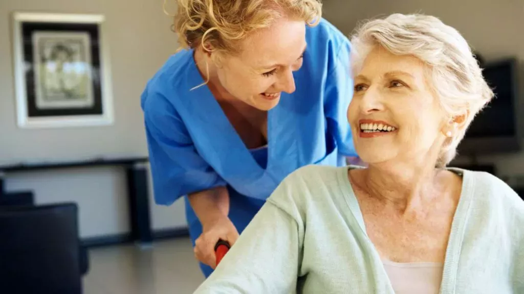 Caregiver Helping An Elderly Woman