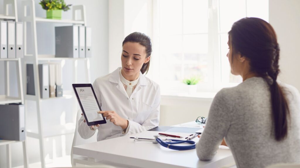 Doctor Showing A Patient Information On A Tablet