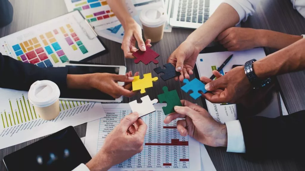 Hands Joining Colorful Puzzle Pieces