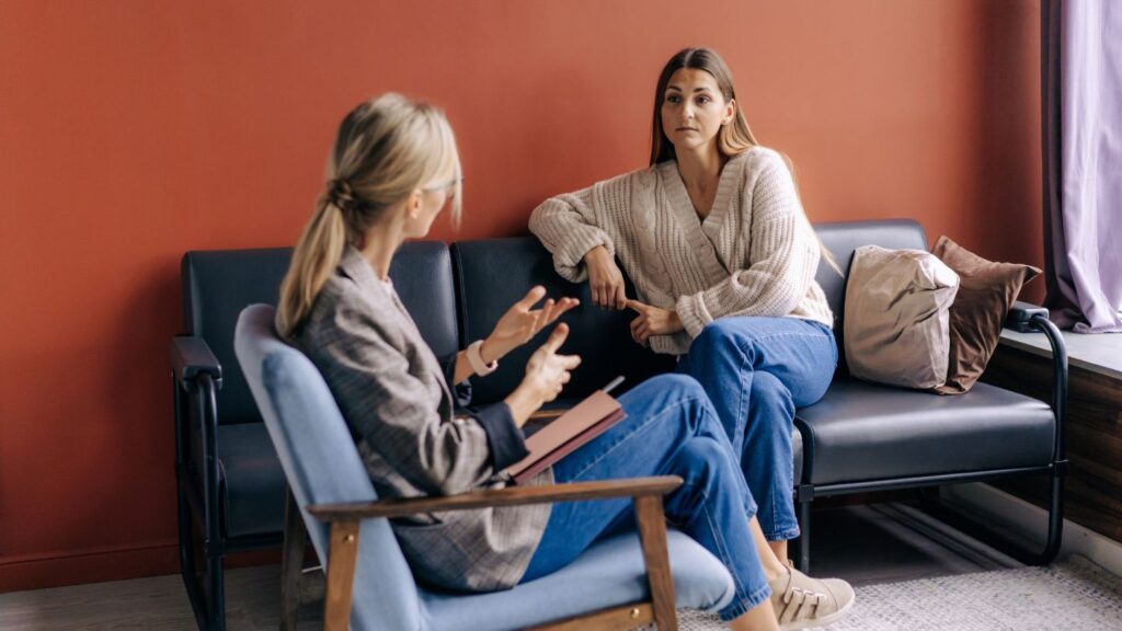Therapist And Client Having A Conversation On A Couch